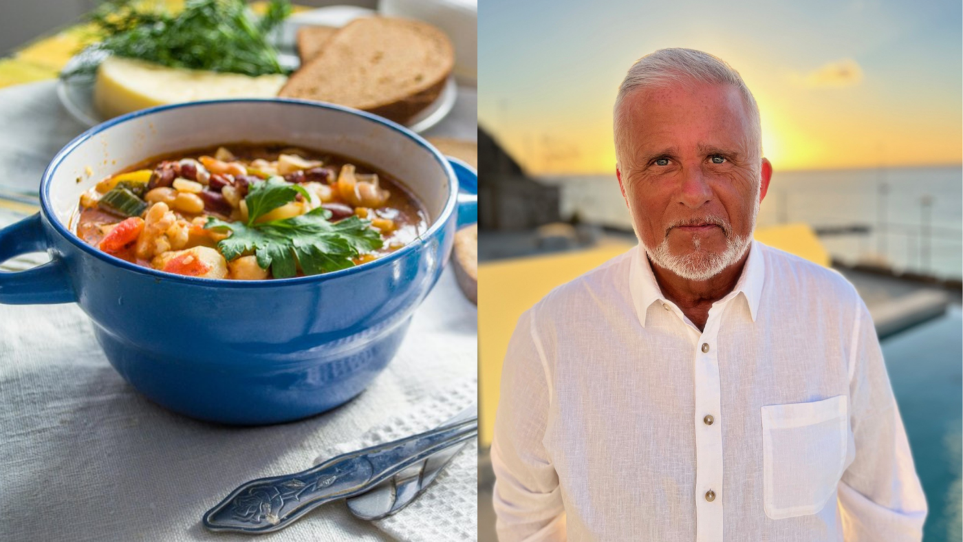 Till vänster syns en blå soppskål fylld med en gryta eller soppa med bönor, grönsaker och färsk persilja ovanpå. I bakgrunden finns brödskivor och en ostbit. Till höger syns en äldre man med vitt hår och skägg, klädd i vit skjorta, stående utomhus i solnedgång vid vatten.